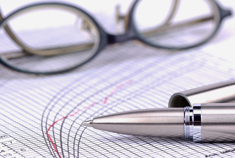 A pen and pair of glasses rest on a paper with a line graph of score conversion between the LSAT and LSAT-Flex.