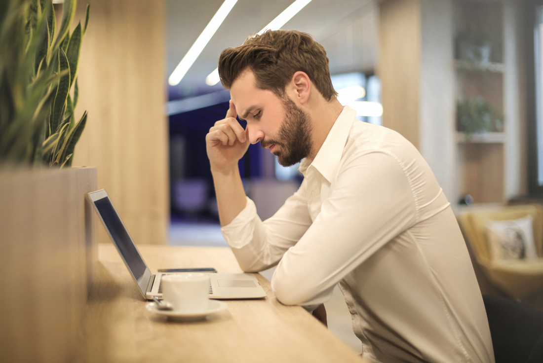 Man looking at a laptop screen thinking about how to approach an LSAT logic game.